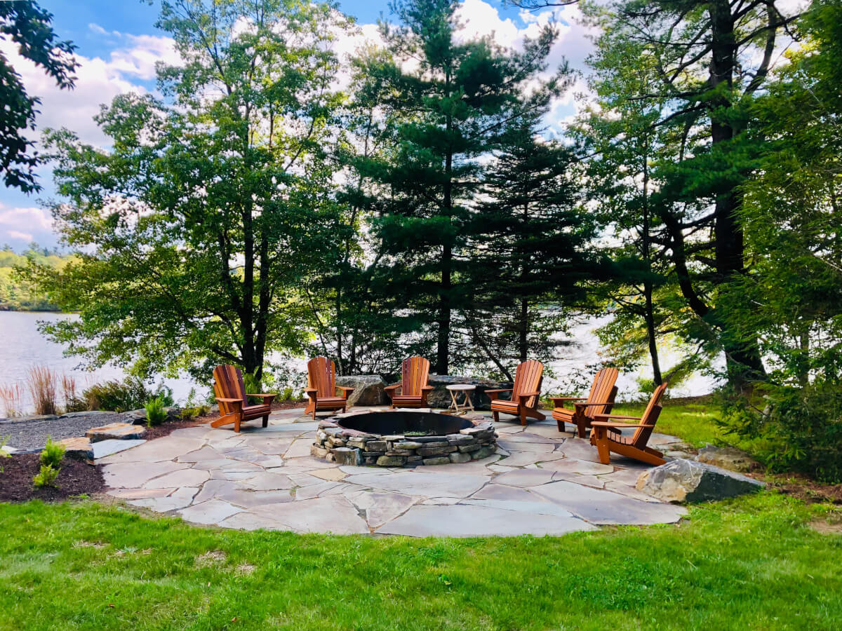 Flagstone fire pit area surrounded by natural landscaping