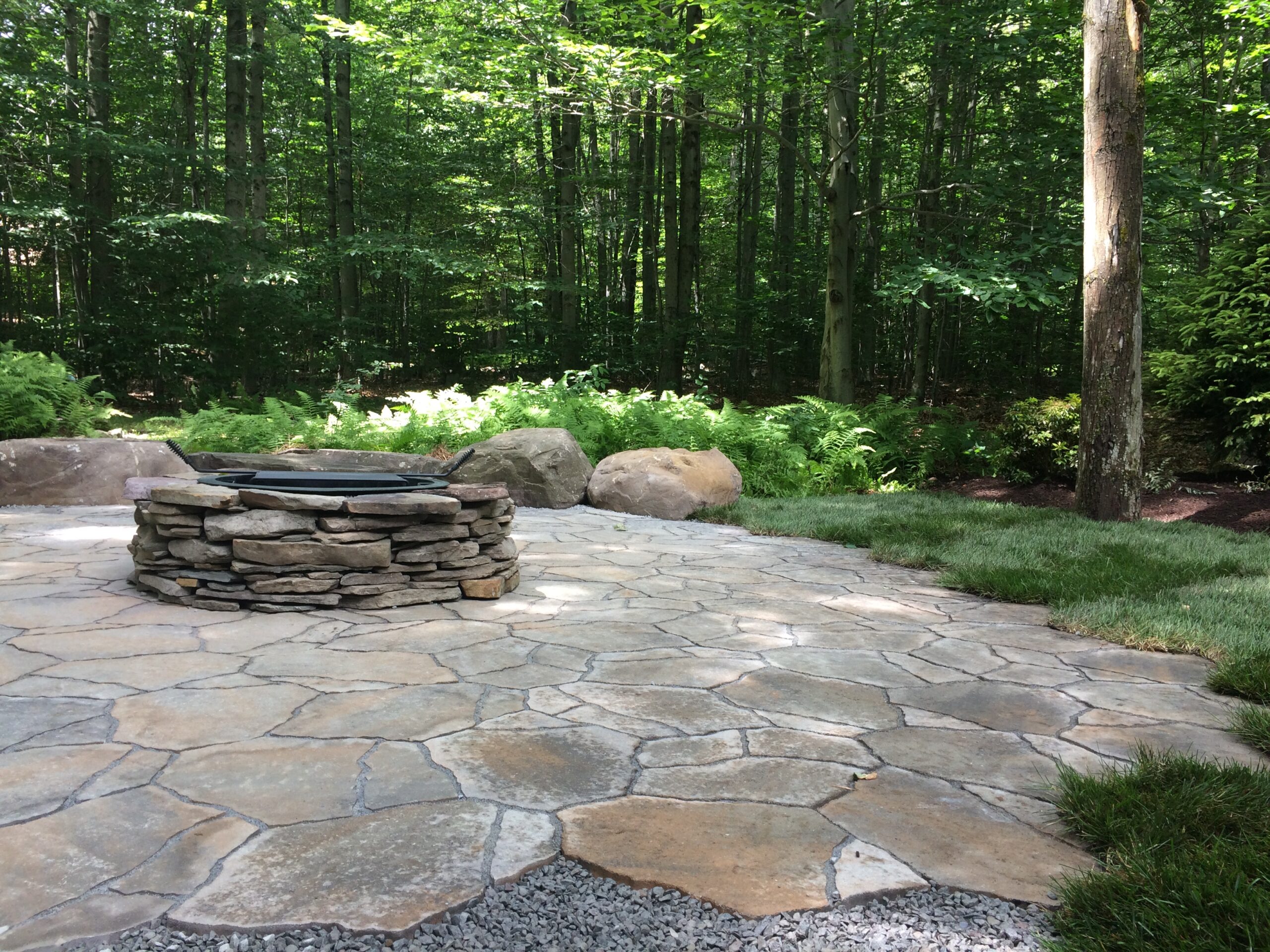 Natural stone retaining wall and patio by Erb's Landscaping