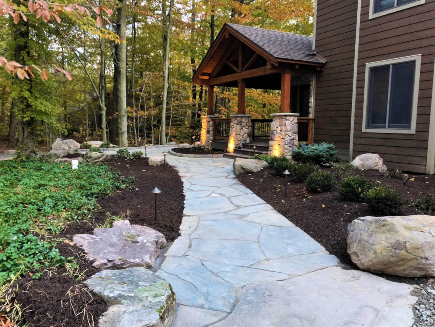 Curved stone walkway with border plantings alongside residential property